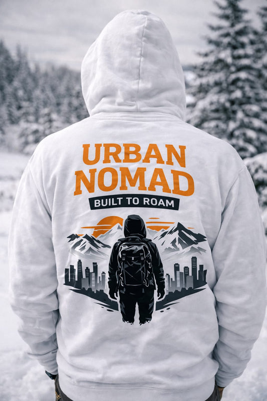 Person wearing a white hoodie with 'Urban Nomad' design in a snowy landscape